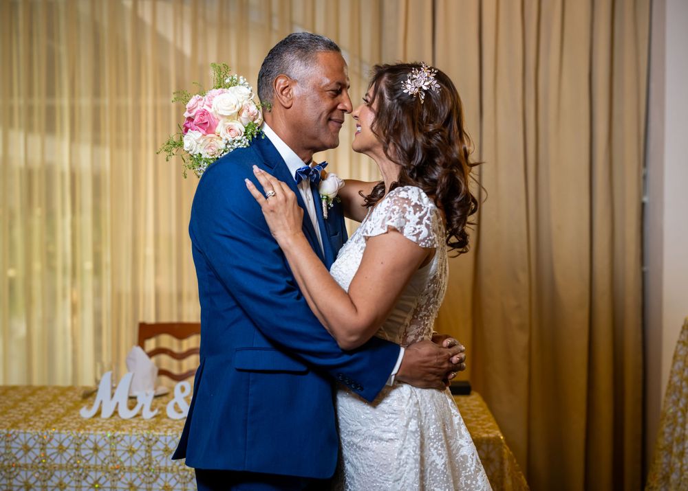 Newlyweds sharing intimate dance in formal wedding attire.