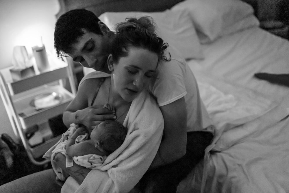 Black and white image capturing a quiet moment with a newborn.