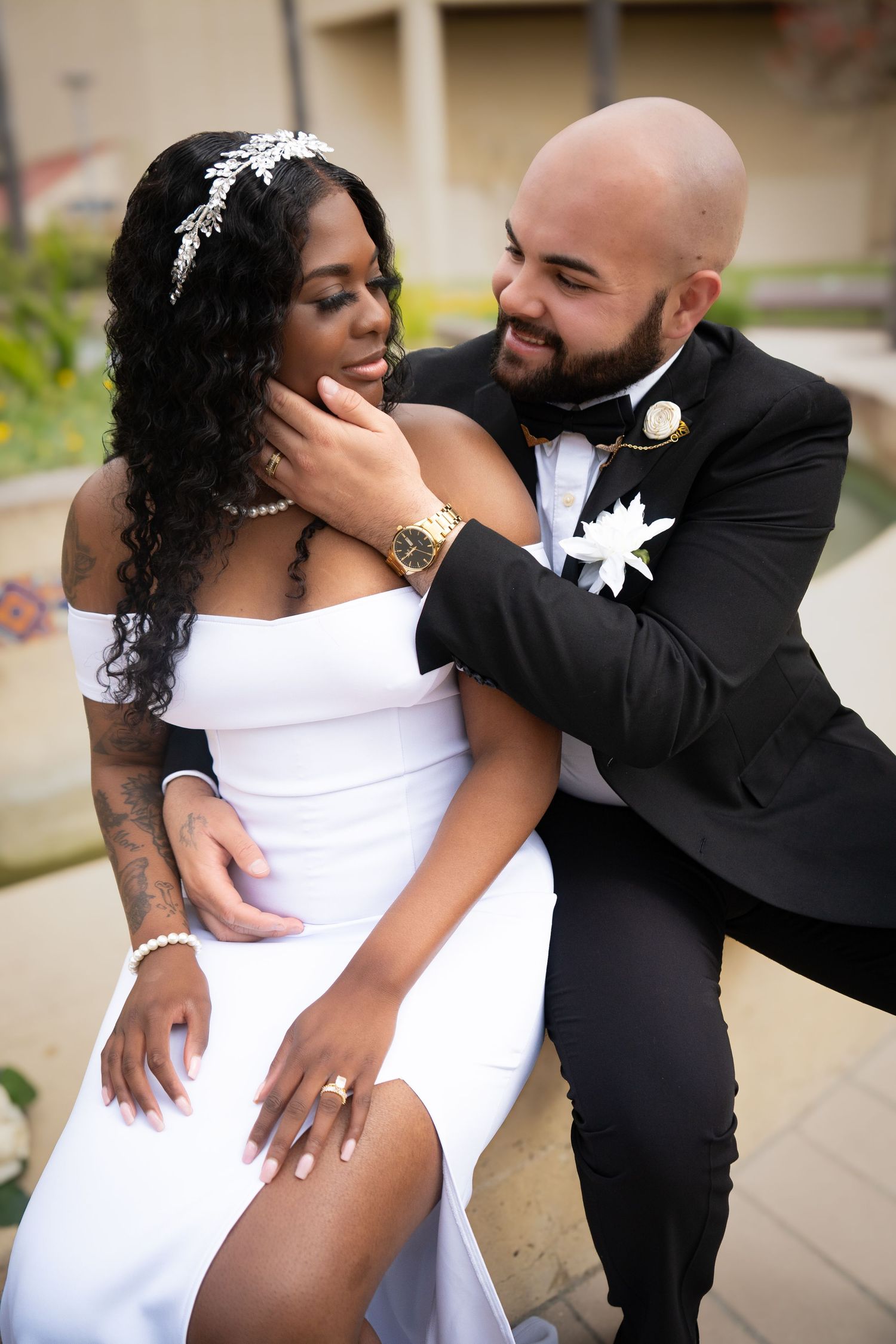 A romantic wedding portrait of a couple sharing an intimate moment in formal attire.