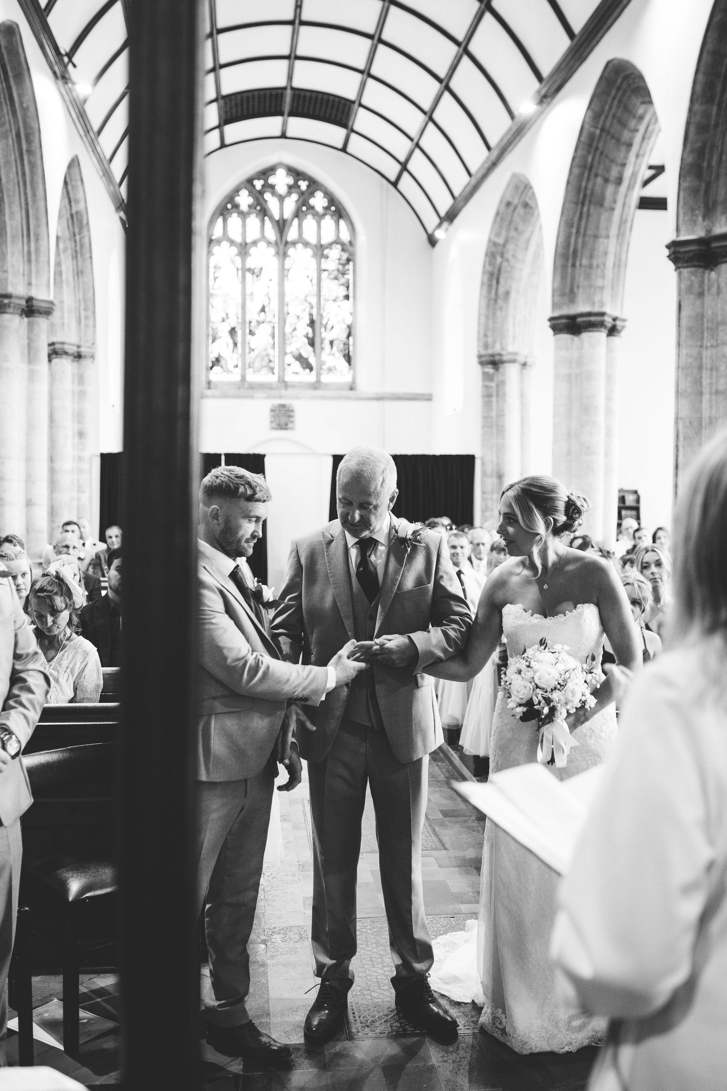 Wedding ceremony in a historic church with vaulted ceilings and stained glass windows.