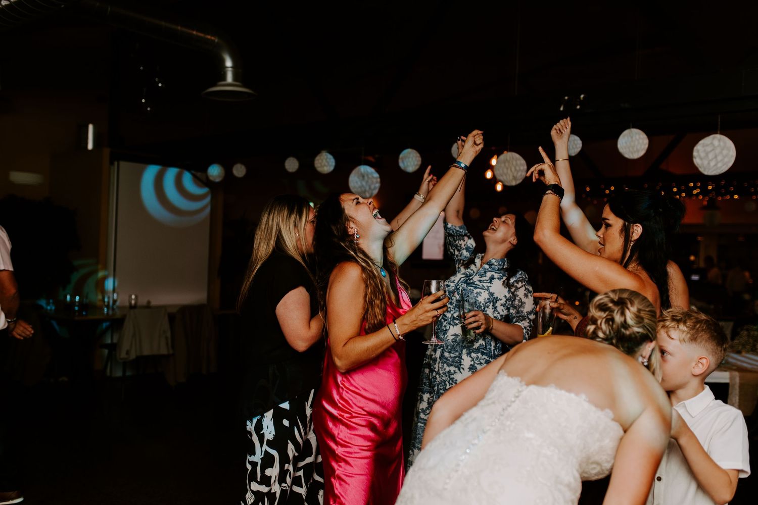 Wedding reception dance floor with party lights and celebrating guests.