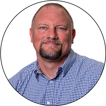 Professional headshot of someone wearing a blue checkered button-up shirt against a white background.