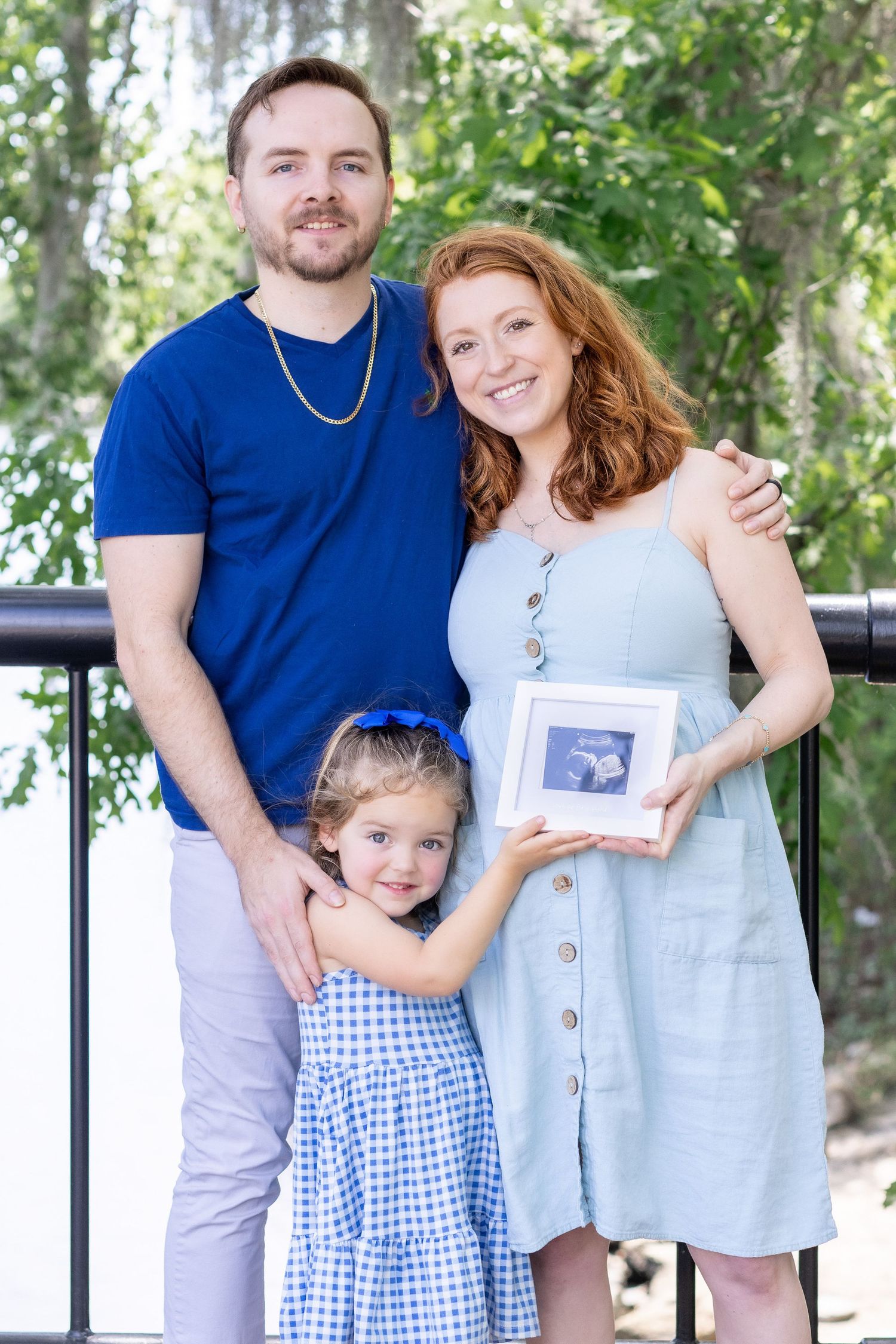 Outdoor maternity session under trees in a park with her family, captured by Tasha Cannaday a Essex County photographer