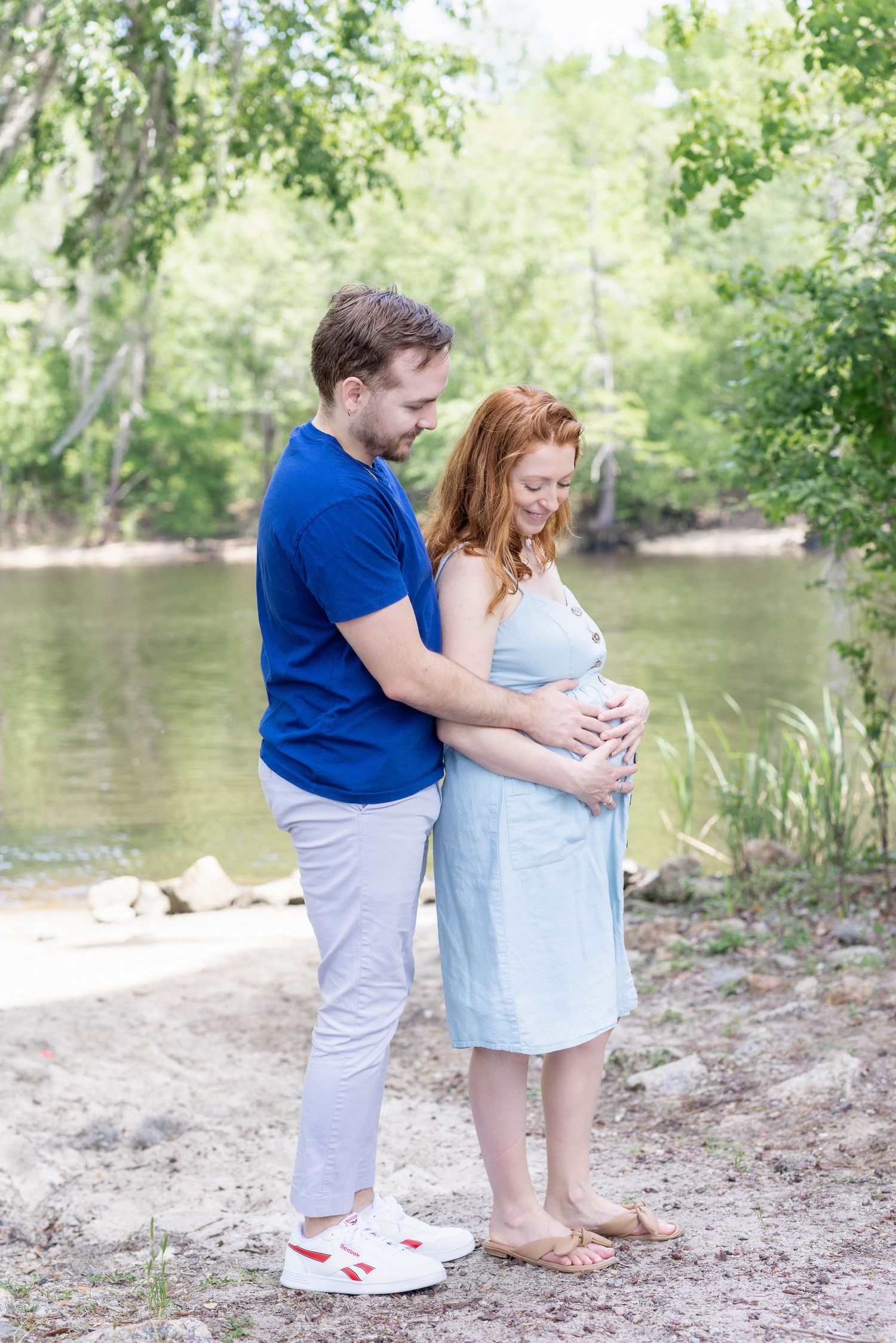 Happy couple embracing during golden hour maternity session in Windsor.