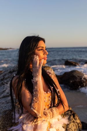 Artistic beach portrait with delicate dress details during golden hour.