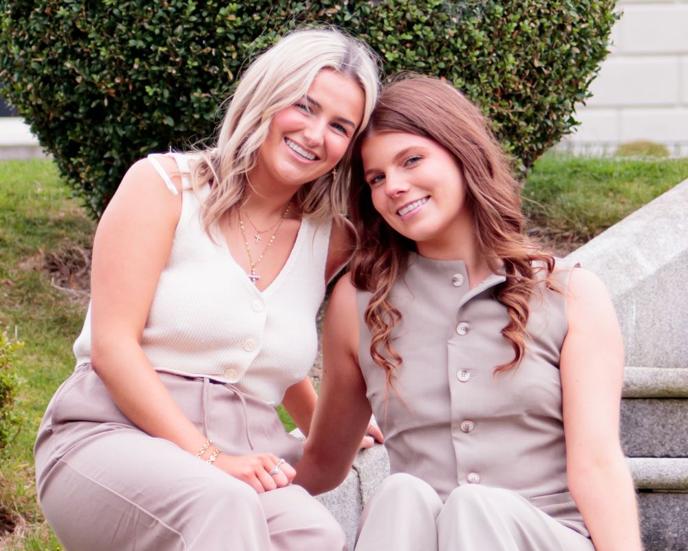 Casual outdoor photoshoot featuring coordinated beige outfits against natural backdrop.