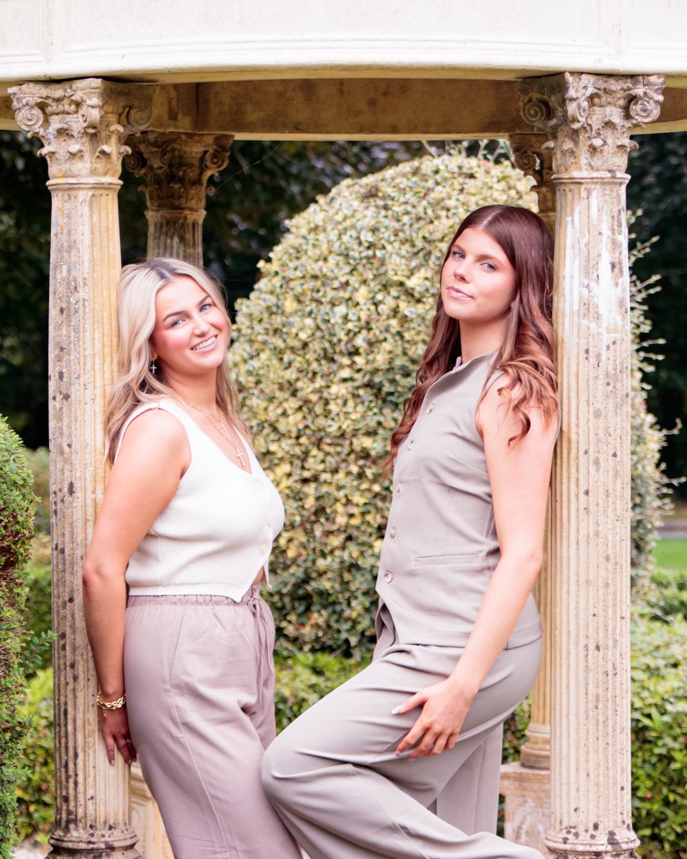 Photoshoot at a classical gazebo with ornate columns surrounded by lush greenery.