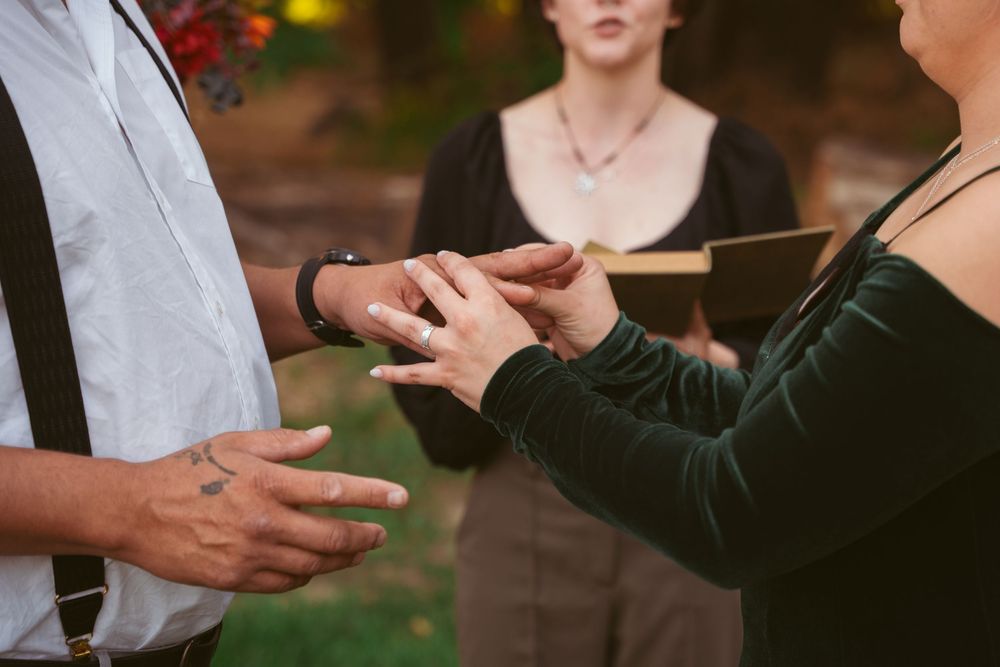 Two people reach out to hold hands during an outdoor celebration.
