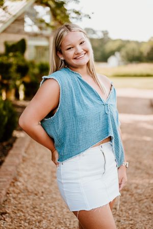 Casual summer outfit featuring a light blue cropped top and white denim mini skirt in an outdoor setting.