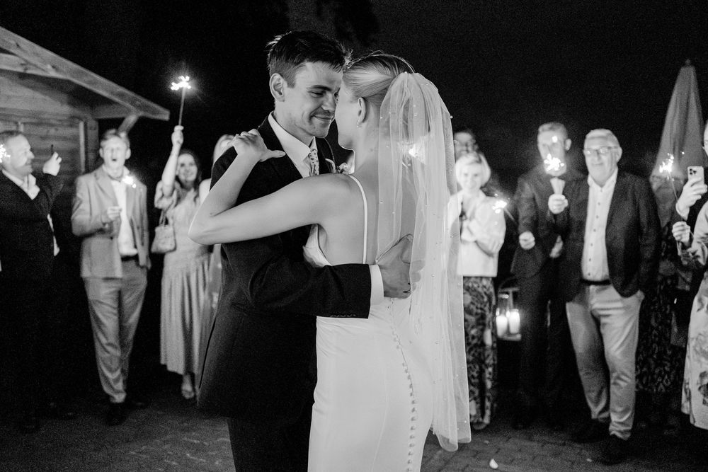Wedding reception guests enjoy dancing and celebrating on the dance floor at an evening party.