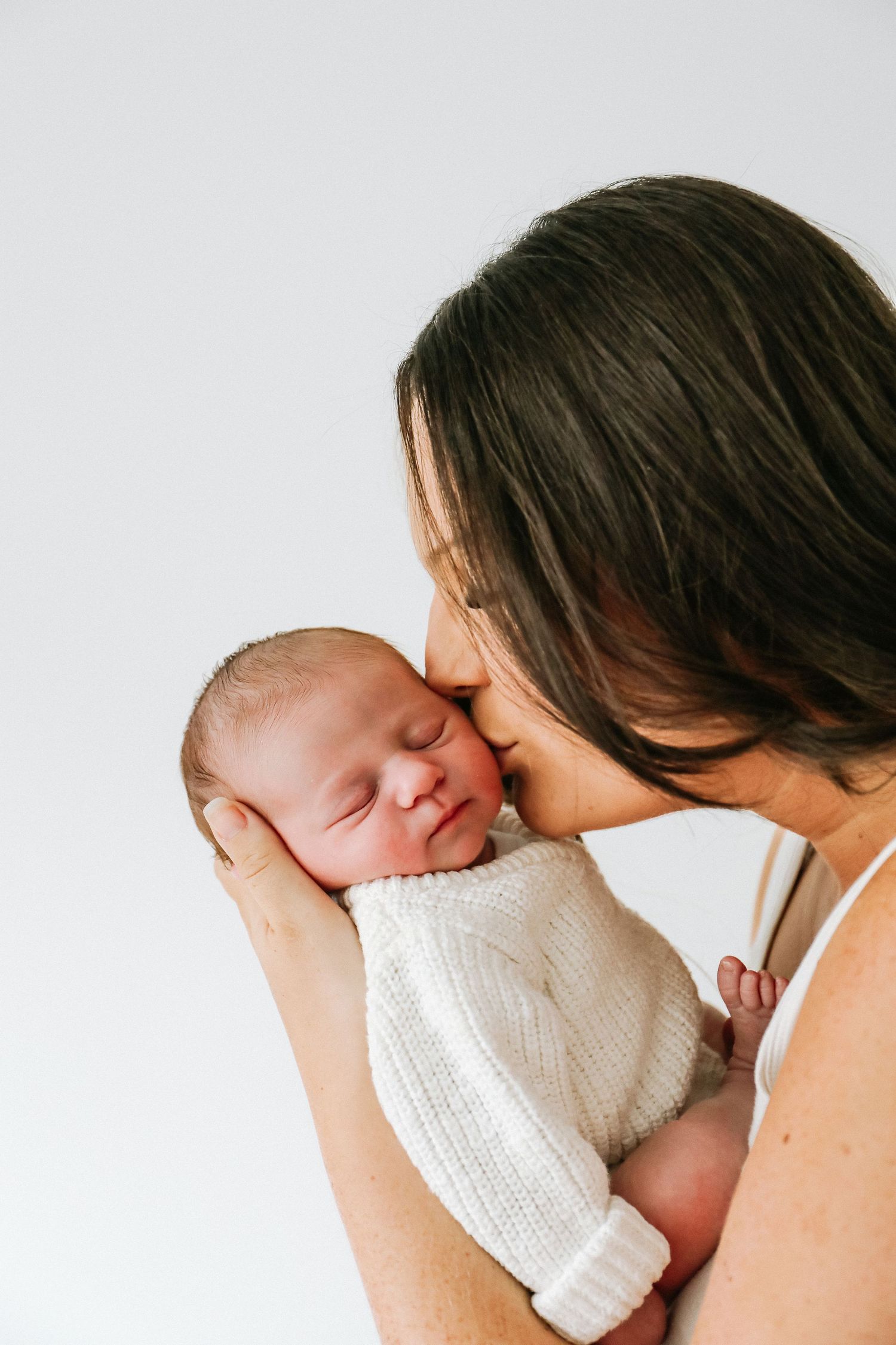 A tender moment captured in soft light as a mum and baby share a gentle nose-to-nose connection, during newborn shoot in Nottingham