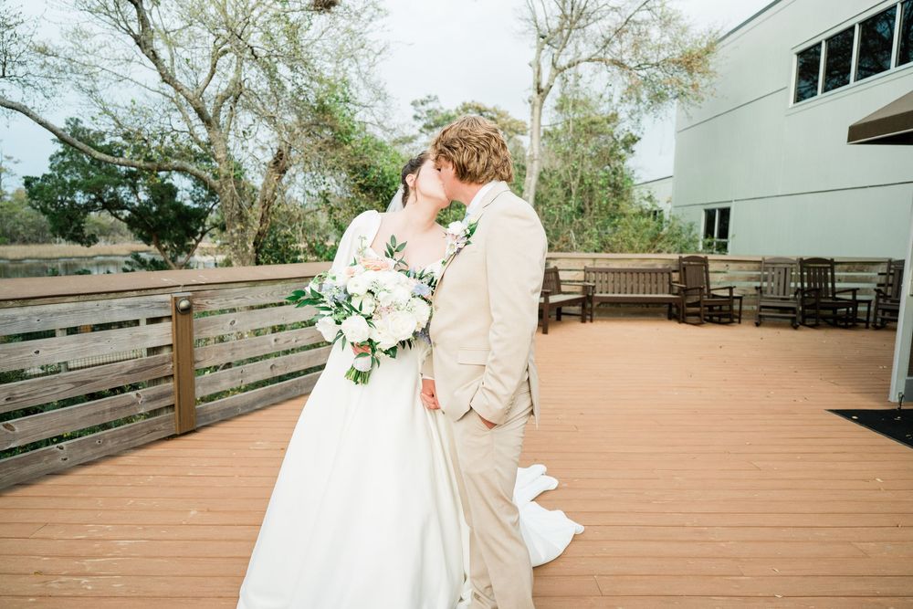 Wedding celebration on an outdoor wooden deck with scenic natural surroundings.