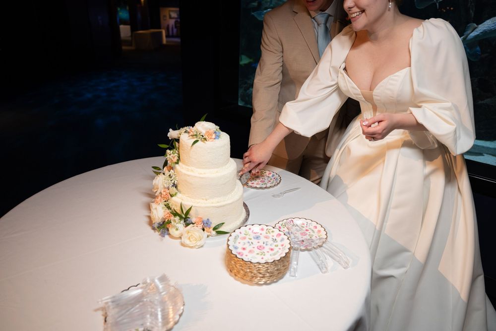 Wedding cake and dessert table with white decorations at reception.