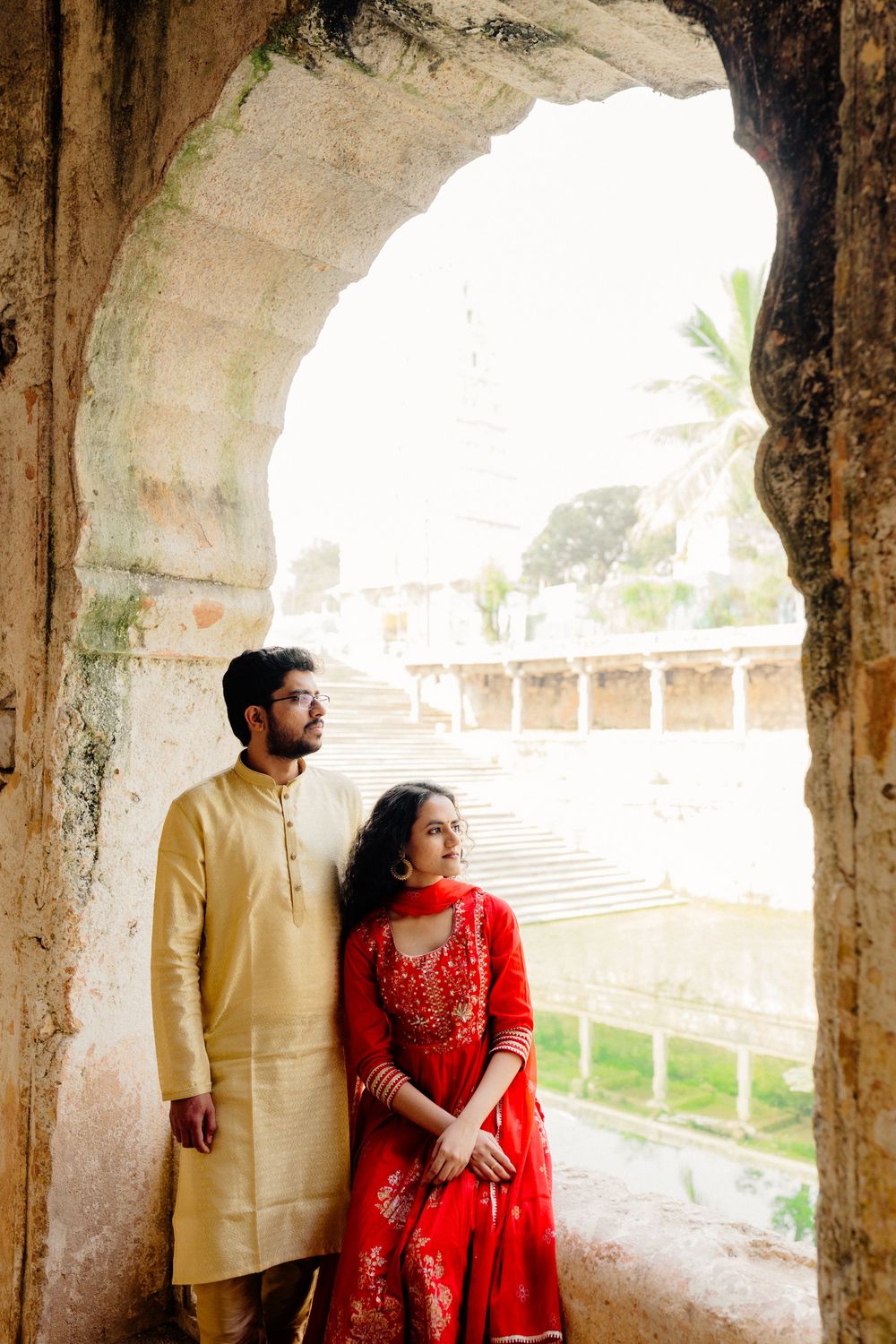 Historic archways and columns create a dramatic corridor view at a classical Indian architectural monument.