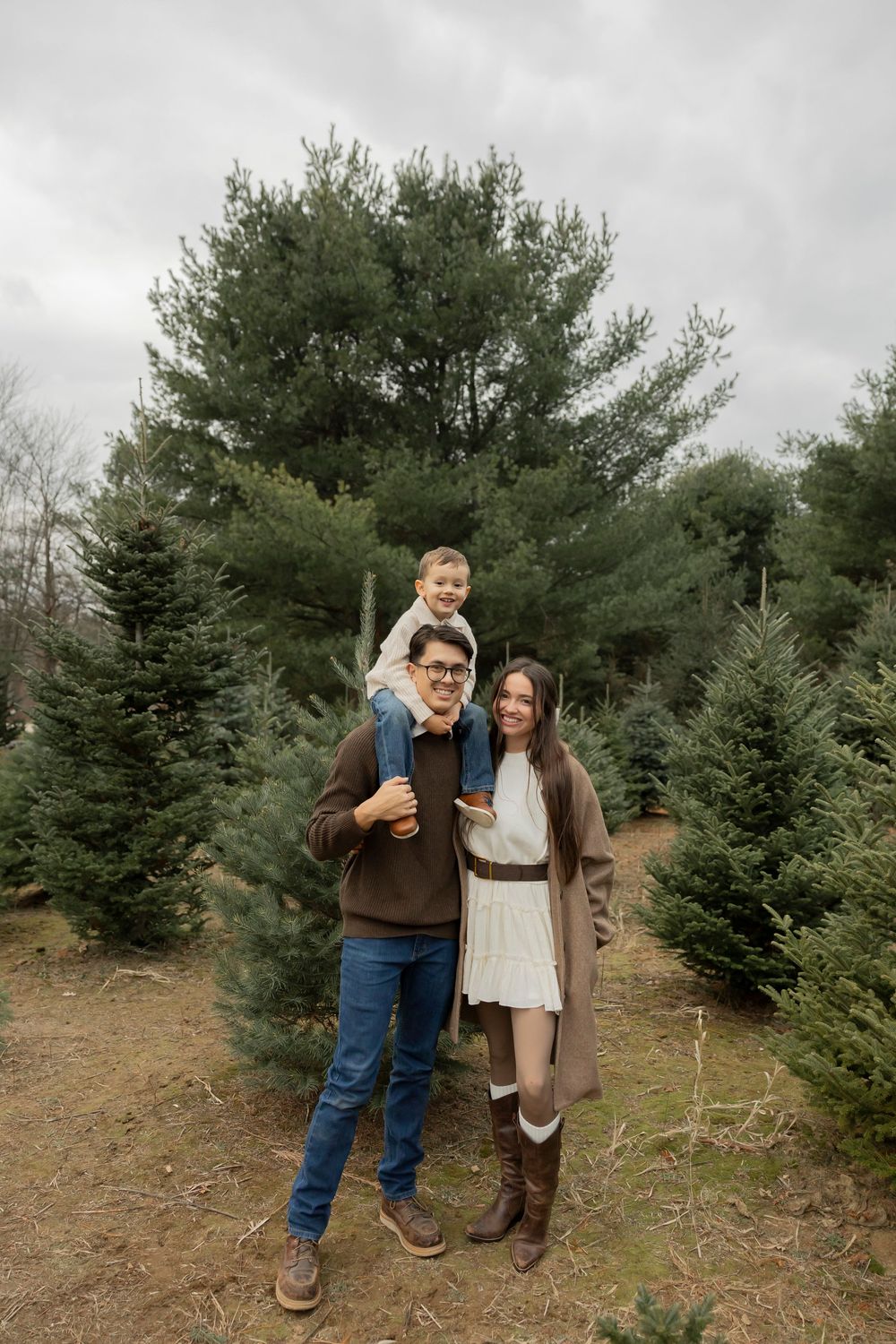 A family shares a tender moment while shopping for Christmas trees at Addison oaks tree farm on an overcast day in Oakland county Michigan