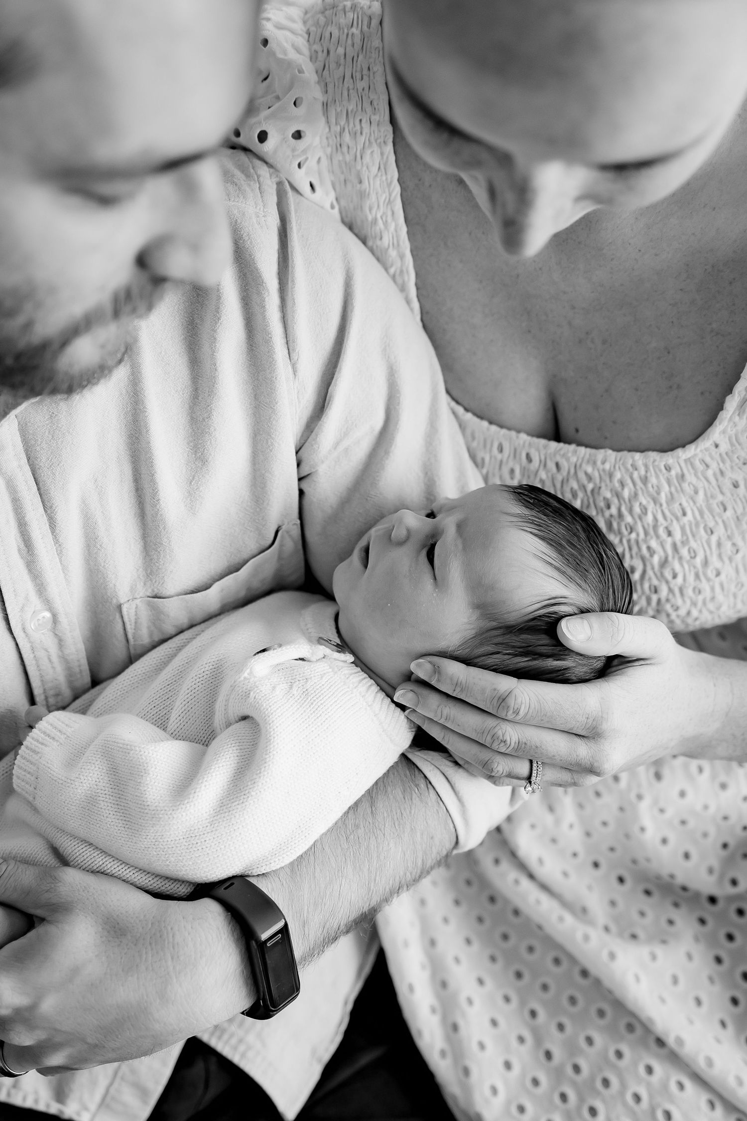 Black and white series of intimate images showing tender close-up moments between parent and newborn baby in hospital.
