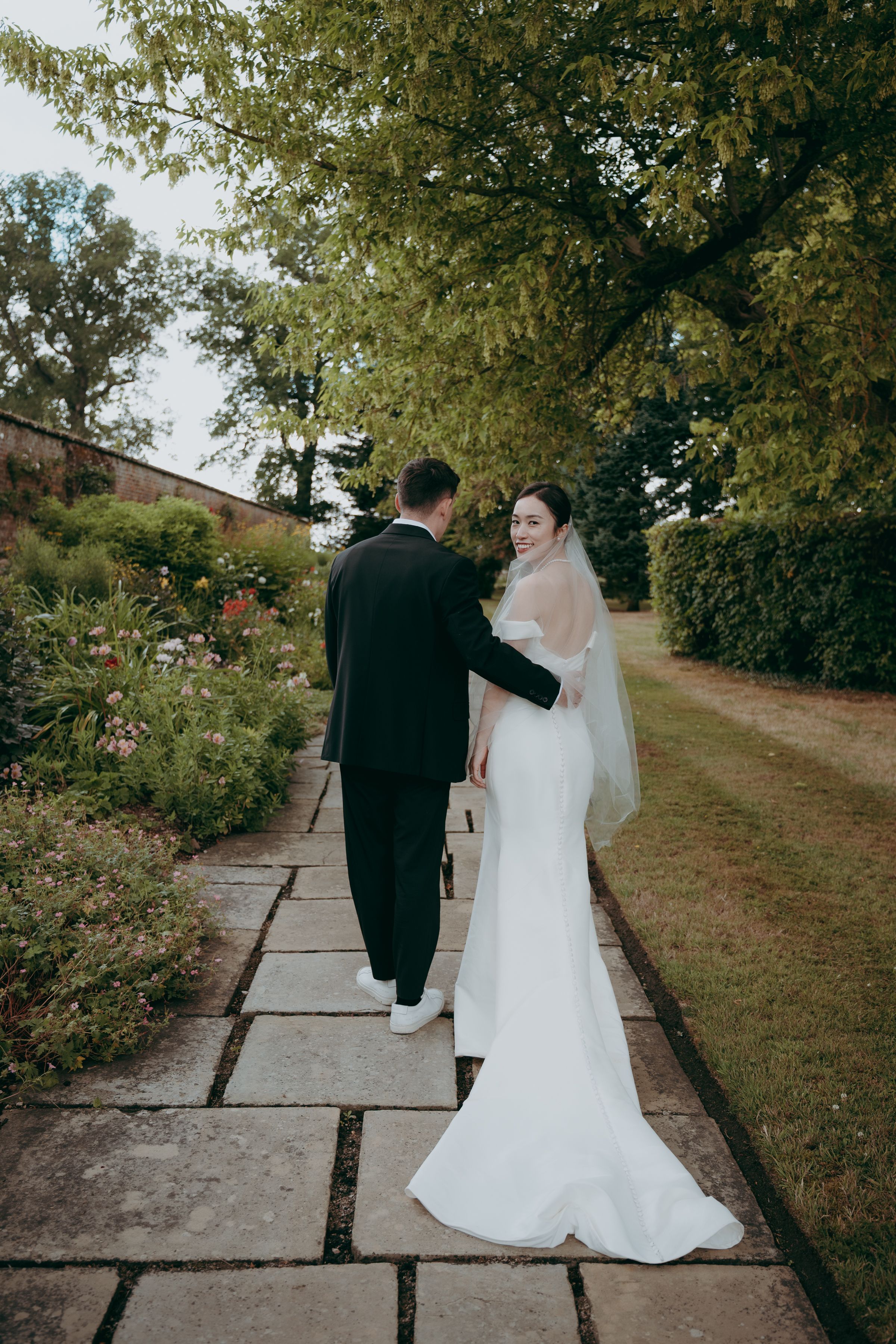 A sequence of romantic wedding photos captured on stone pathways surrounded by autumn trees and foliage.