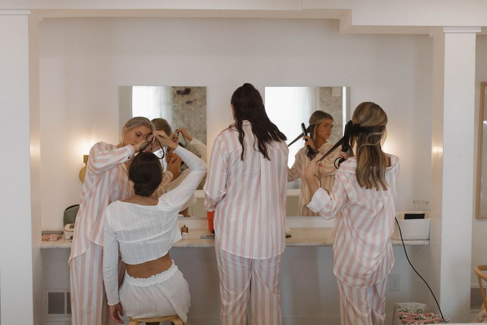 Wedding morning preparations with matching striped robes in bright room.
