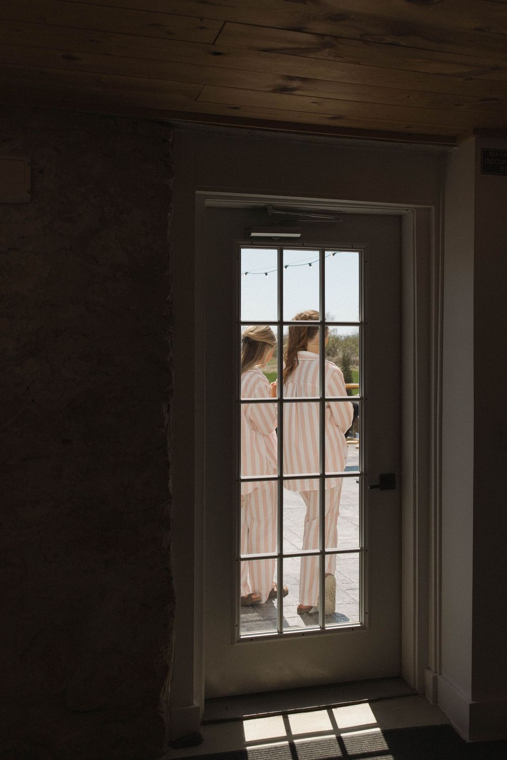Silhouettes visible through a window pane in soft natural light creating a romantic atmosphere.
