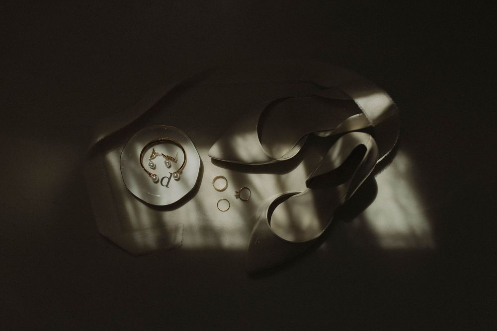 Wedding rings and details captured in moody lighting with bokeh effect.