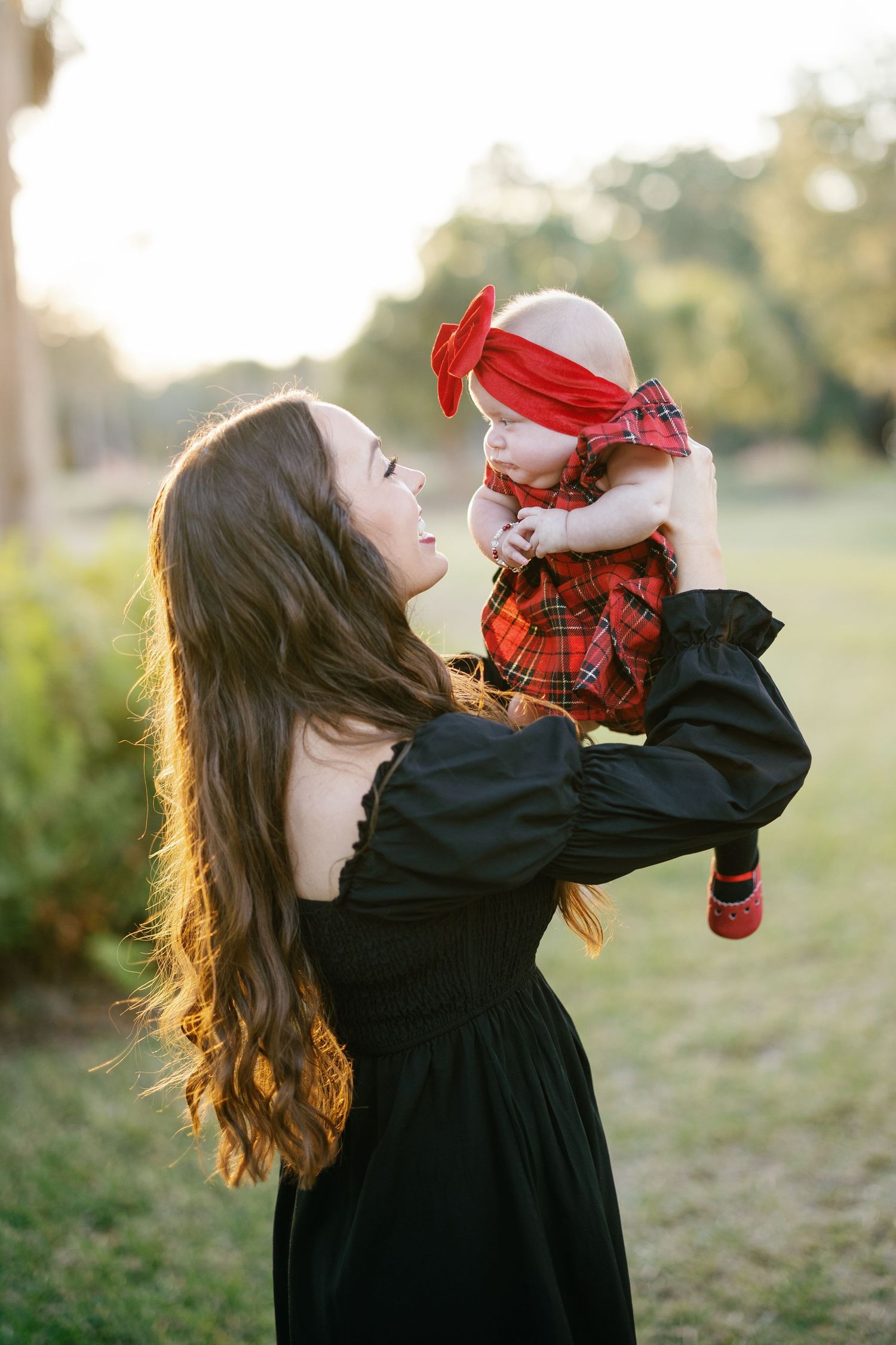 A mother and her baby dressed in Christmas outfits for a sunset photoshoot.