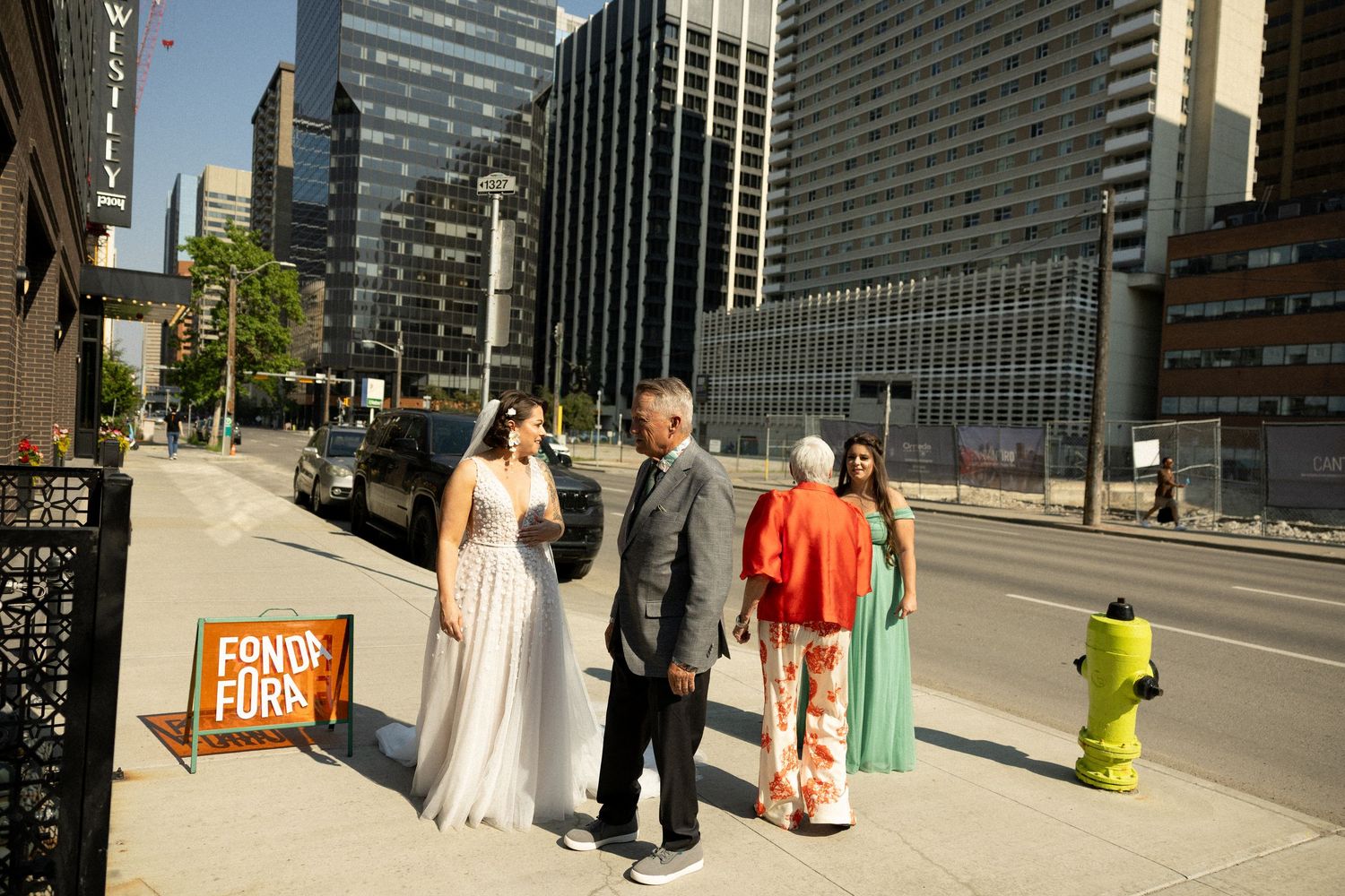 A modern urban cityscape with tall glass buildings and people walking on a sunny day.