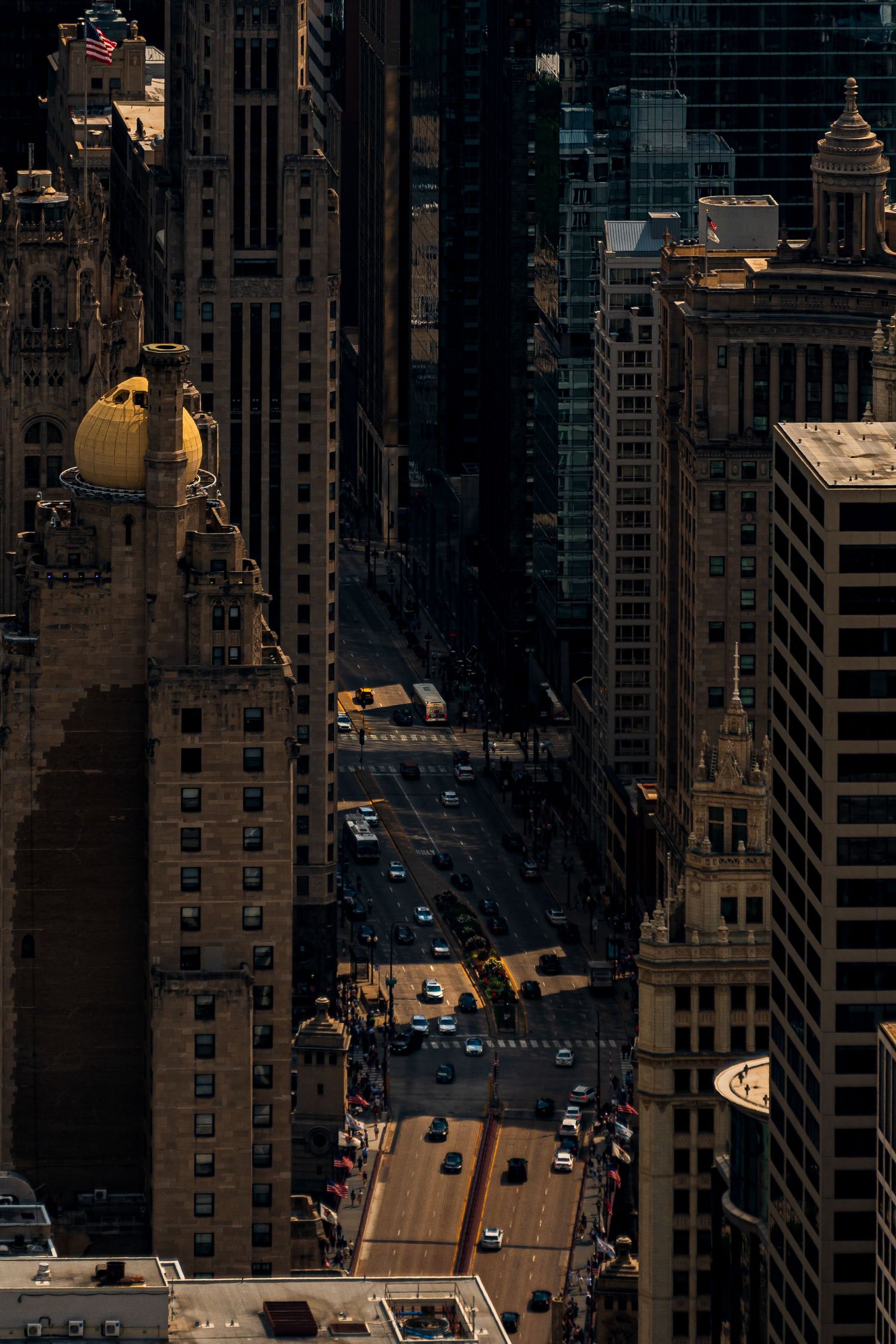 Aerial view of dark city buildings casting shadows on streets below.