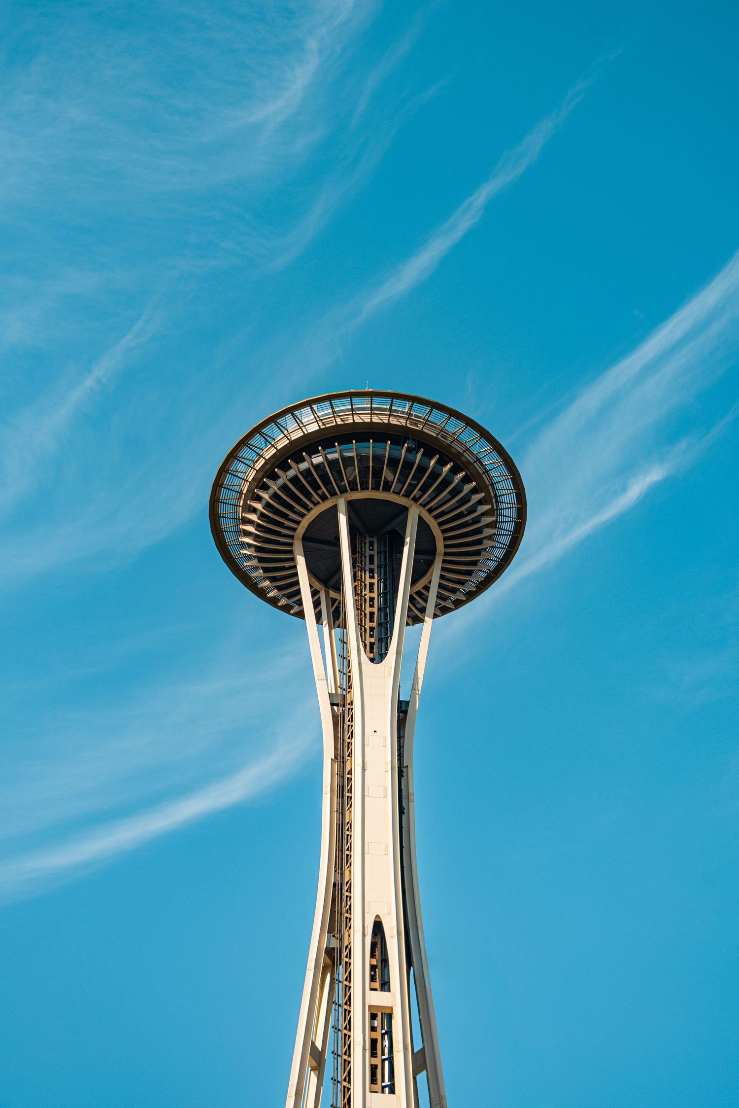 Seattle Space Needle observation tower photographed against bright blue sky with wispy clouds.