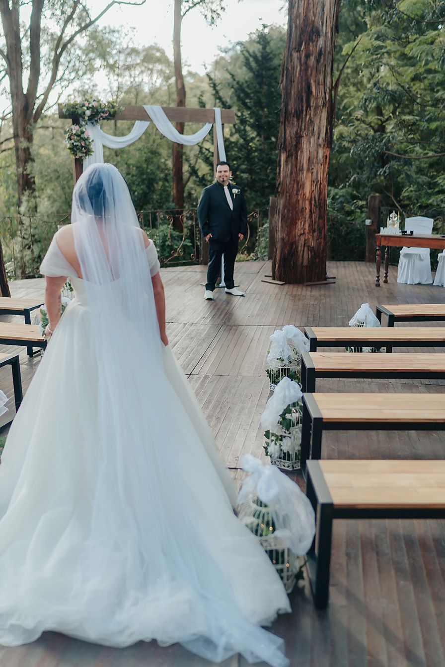 A sequence of shots showing the flowing train of a white wedding gown on a wooden deck surrounded by trees.