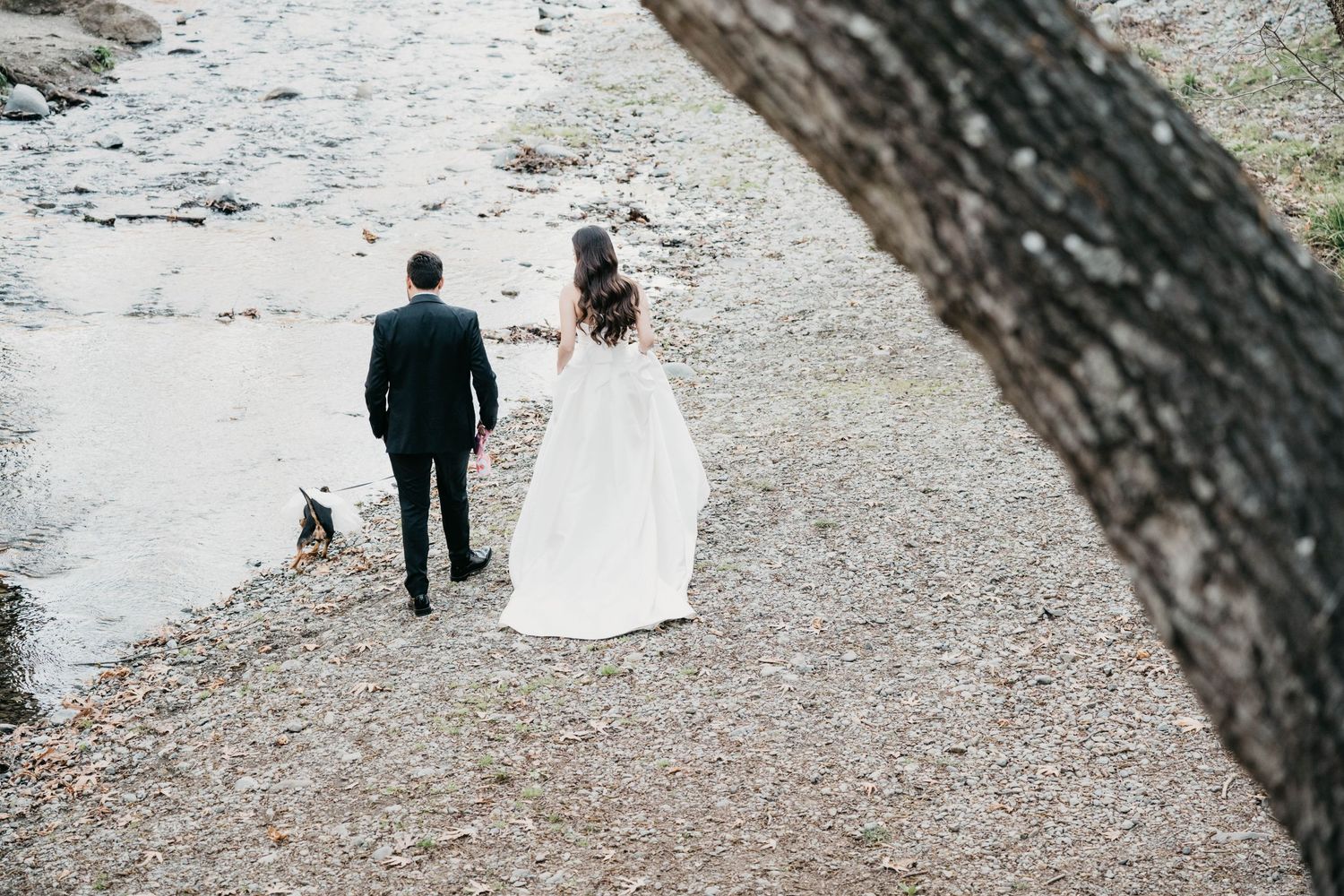 Four black and white photos of a couple sharing tender moments against a rustic stone wall background.