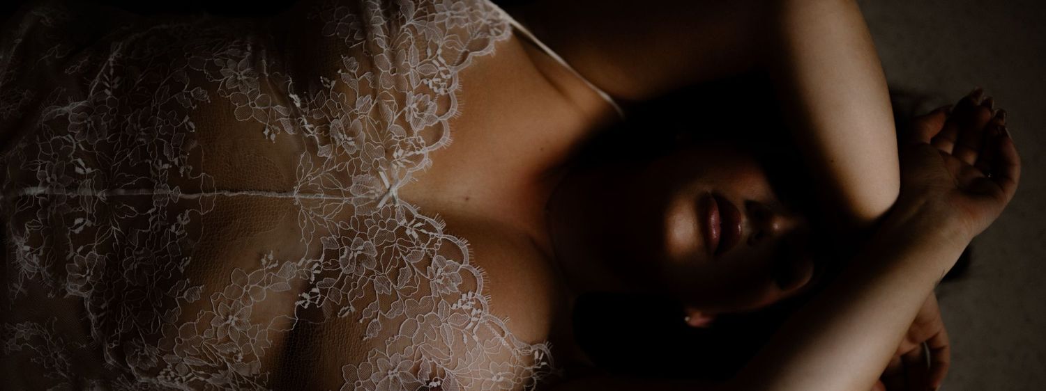 Artistic black and white boudoir photography with delicate lace details and dramatic lighting.