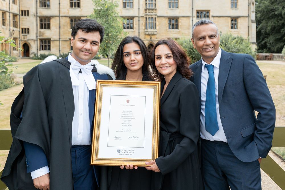 People in formal business attire pose with framed certificates during an award ceremony or recognition event.