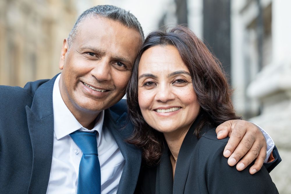 Professional business headshots of diverse team members wearing formal attire and smiling for the camera.