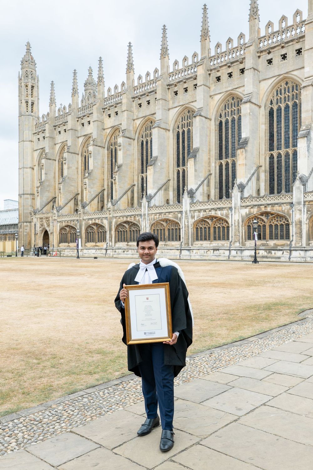 A graduation photo taken in front of the historic Gothic architecture of King's College Chapel at Cambridge University.