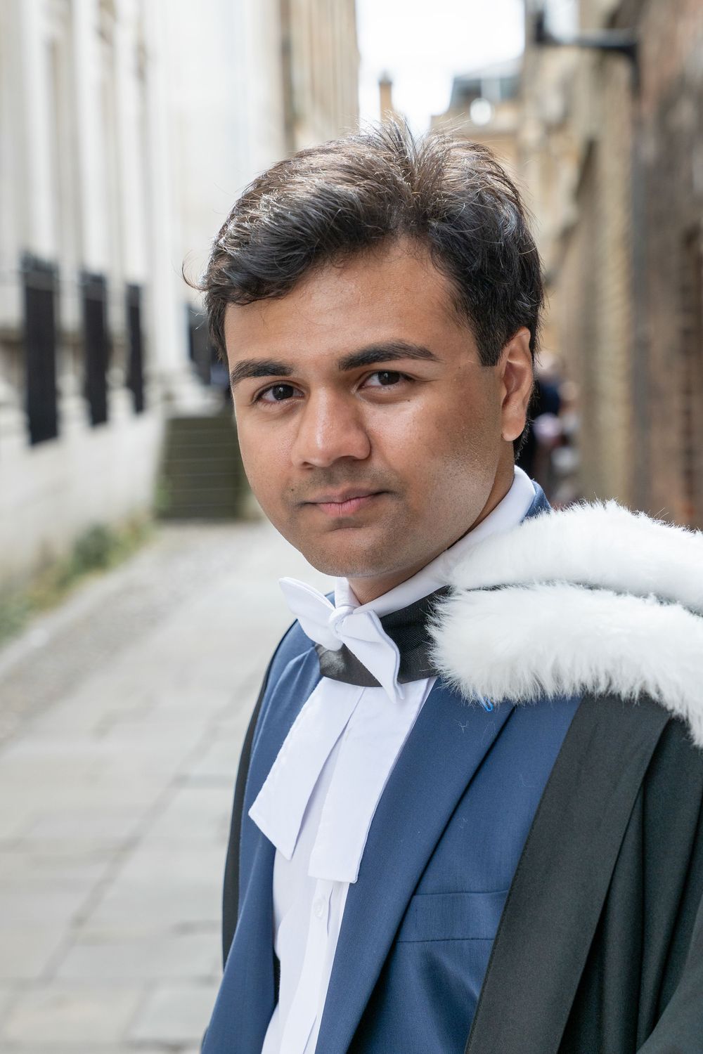 A collage of images showing someone wearing traditional legal attire with a white collar band and navy suit in urban setting.