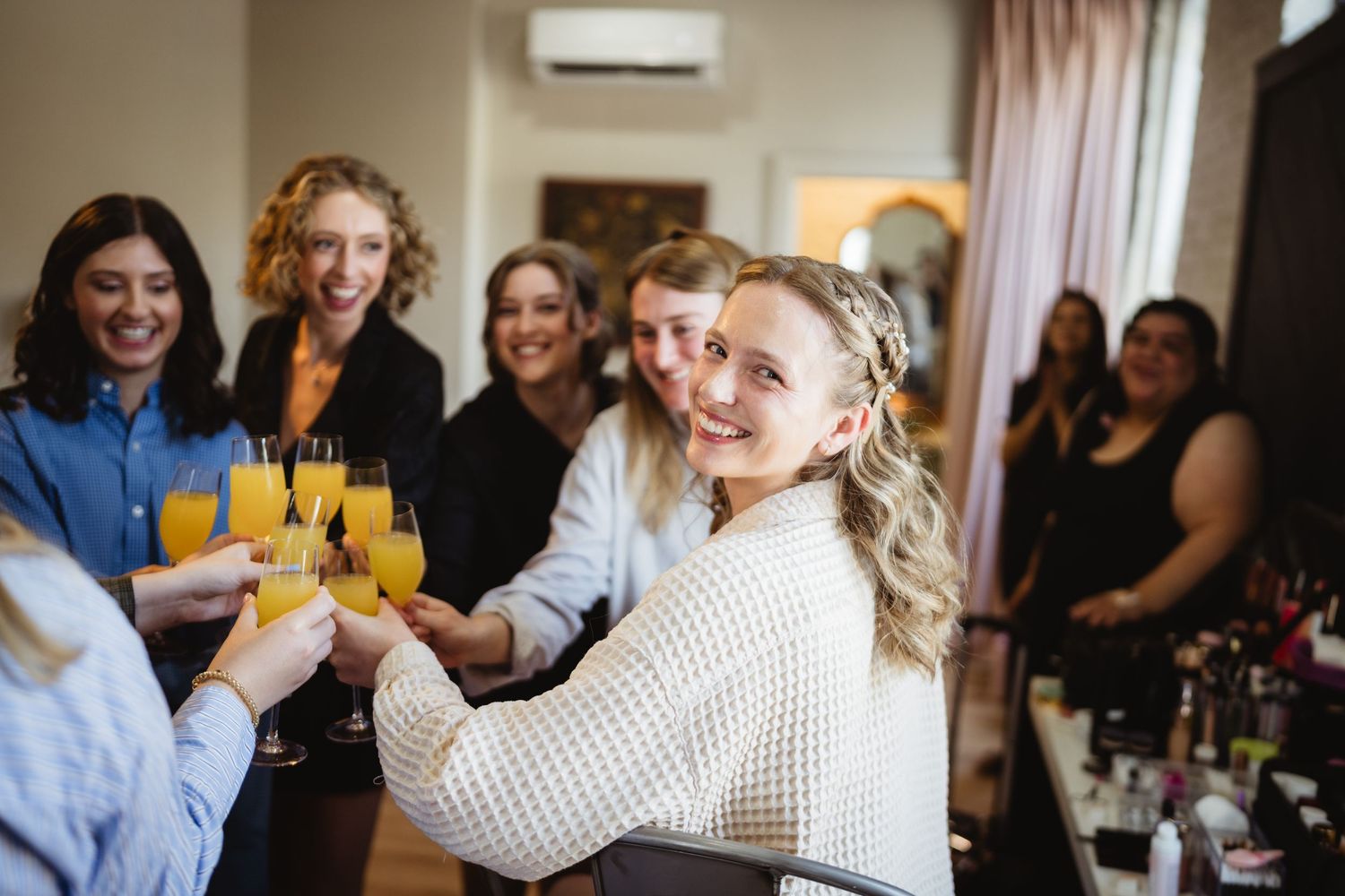 Cheerful group enjoys drinks and conversation at a social gathering with friends seated around a table.