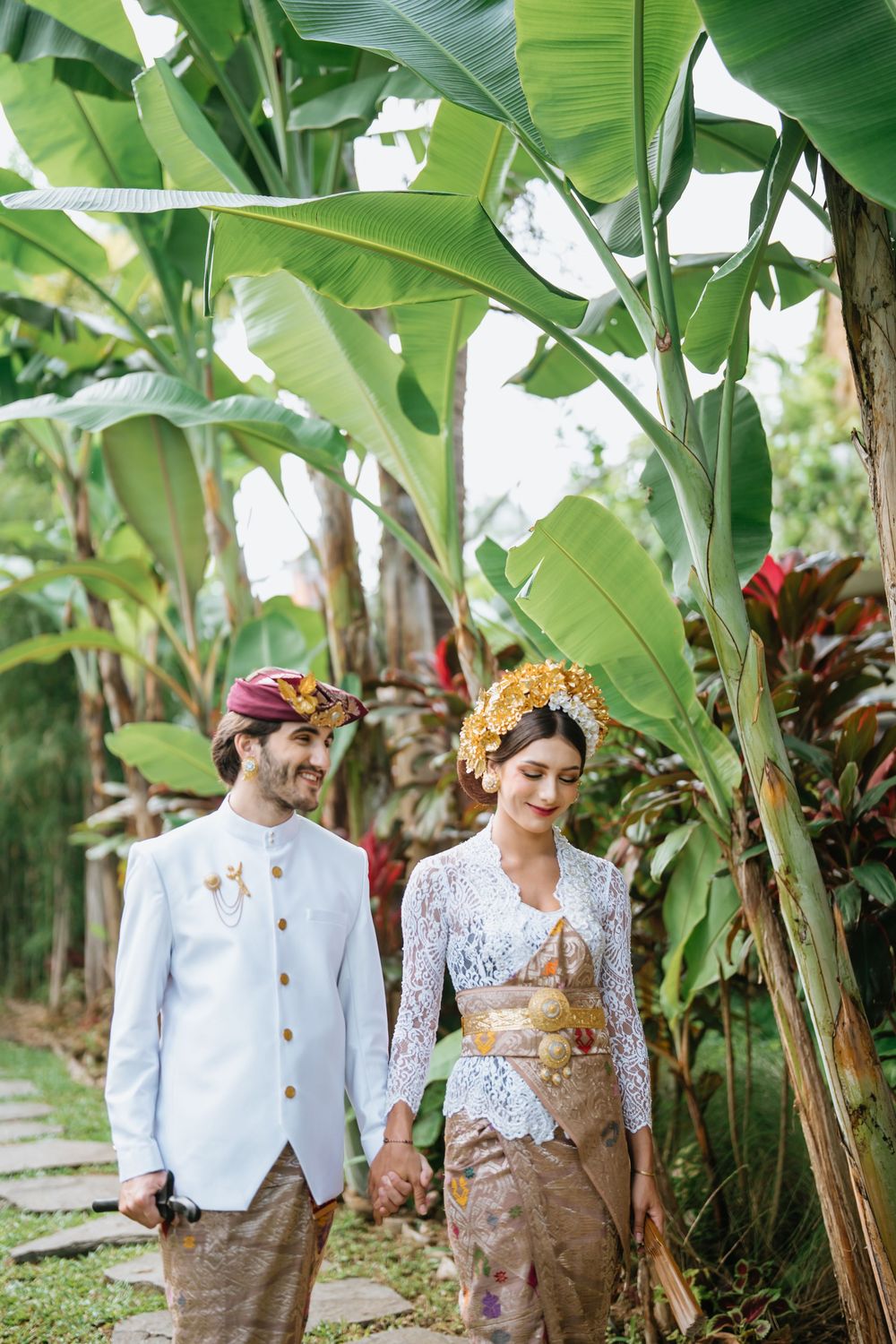 Wedding portraits among banana trees showing traditional Indonesian bridal attire.
