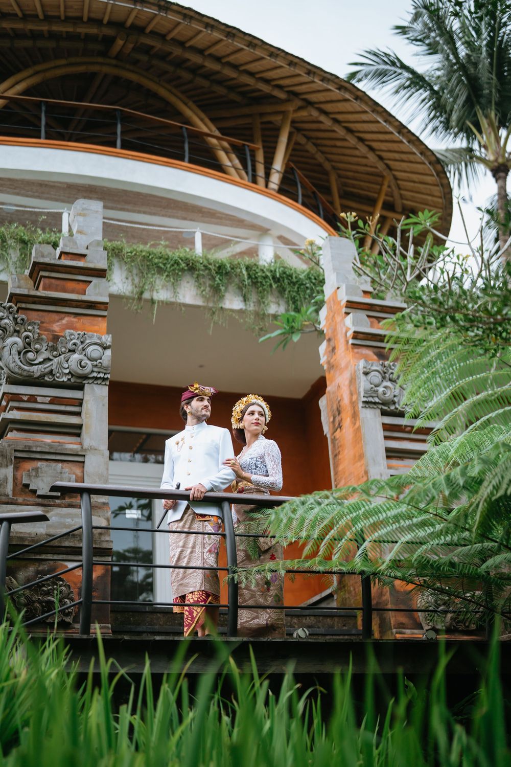 Traditional wedding photography session on a covered wooden terrace with Balinese architectural details.