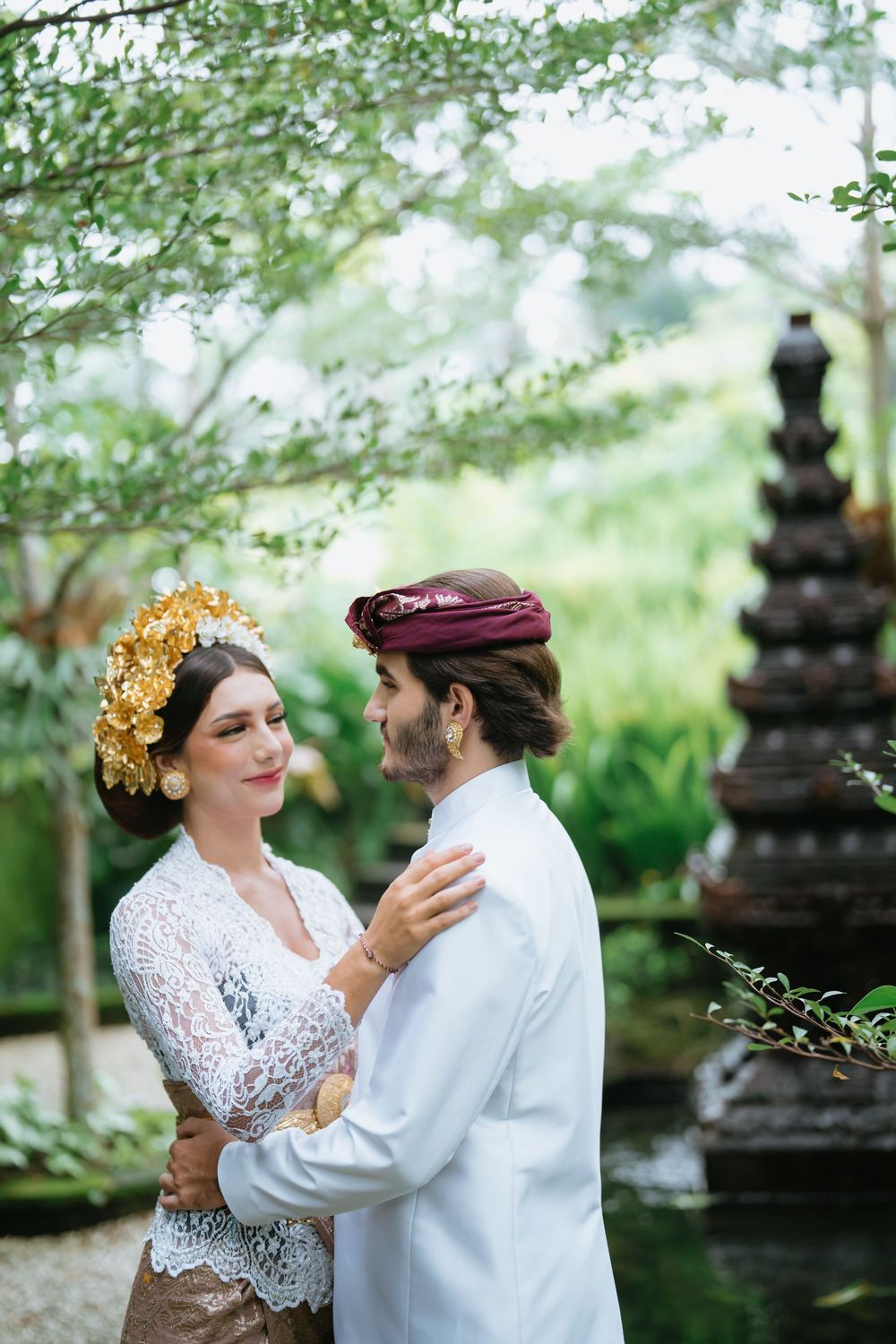 Intimate moment captured in a tropical garden setting with traditional Balinese elements.