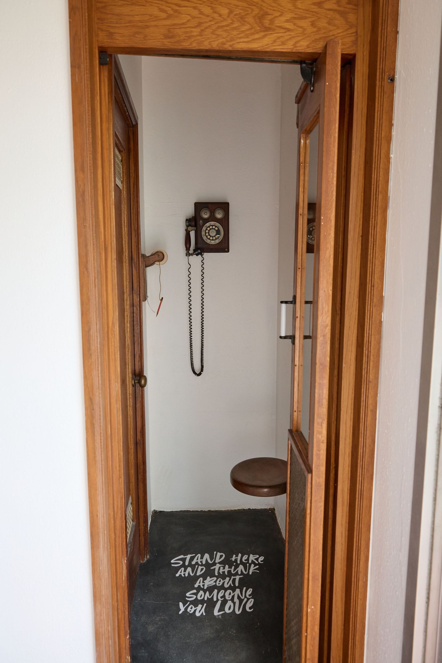 Narrow hallway with wooden trim and doorframes featuring black signage.