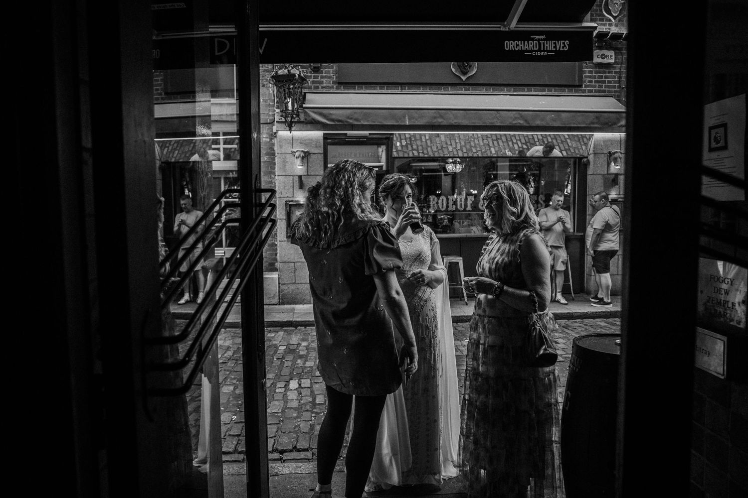 People browse through racks of clothing at a vintage market or thrift store.