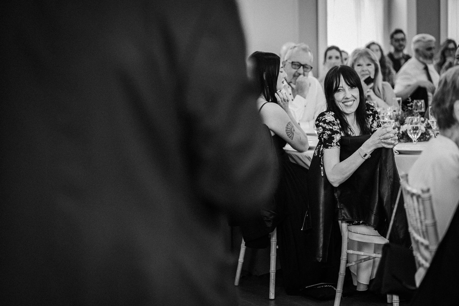 Wedding guests dance and celebrate on a monochrome dance floor during an evening reception.