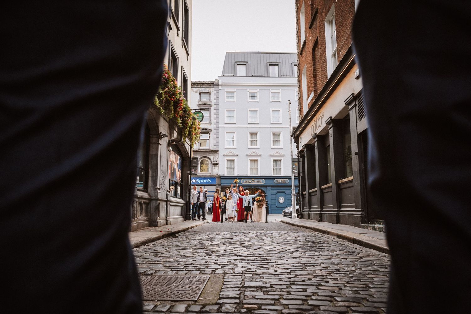 Low angle view of a cobblestone alley in Boston's historic district with buildings towering above.