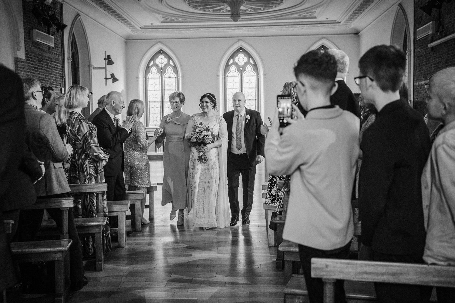 Four similar black and white scenes showing movement through a bright church interior with arched windows.