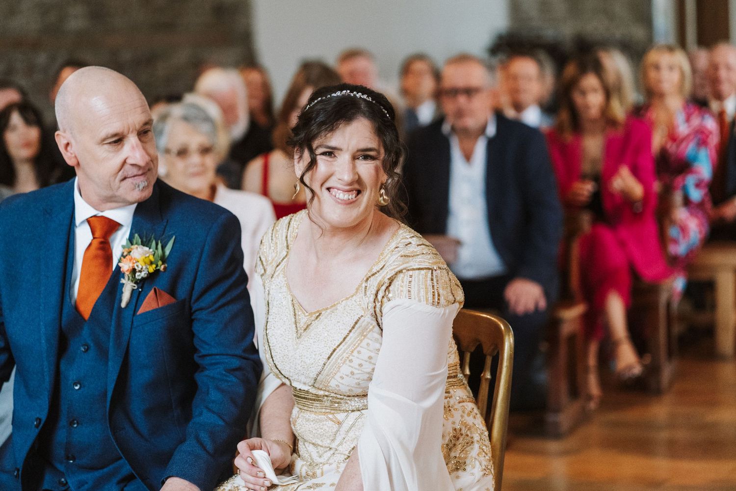 A joyful wedding celebration with guests watching the newlyweds share their first dance in an elegant ballroom setting.