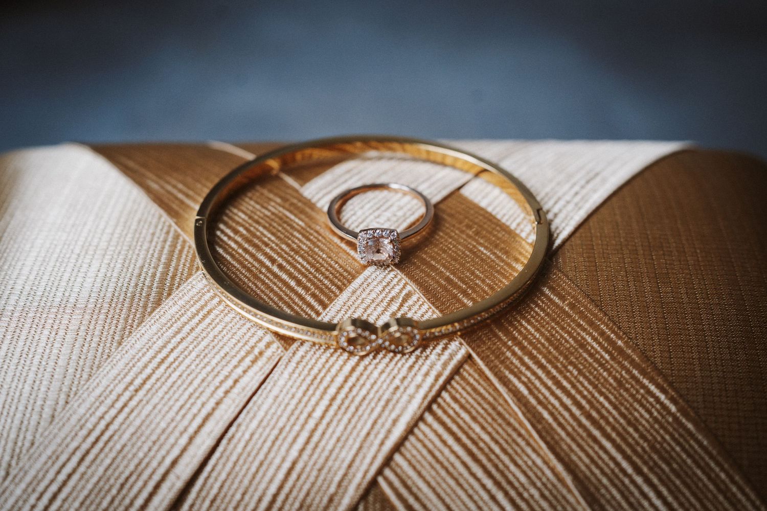 Wedding rings cast dramatic shadows on a textured wooden surface with selective focus.
