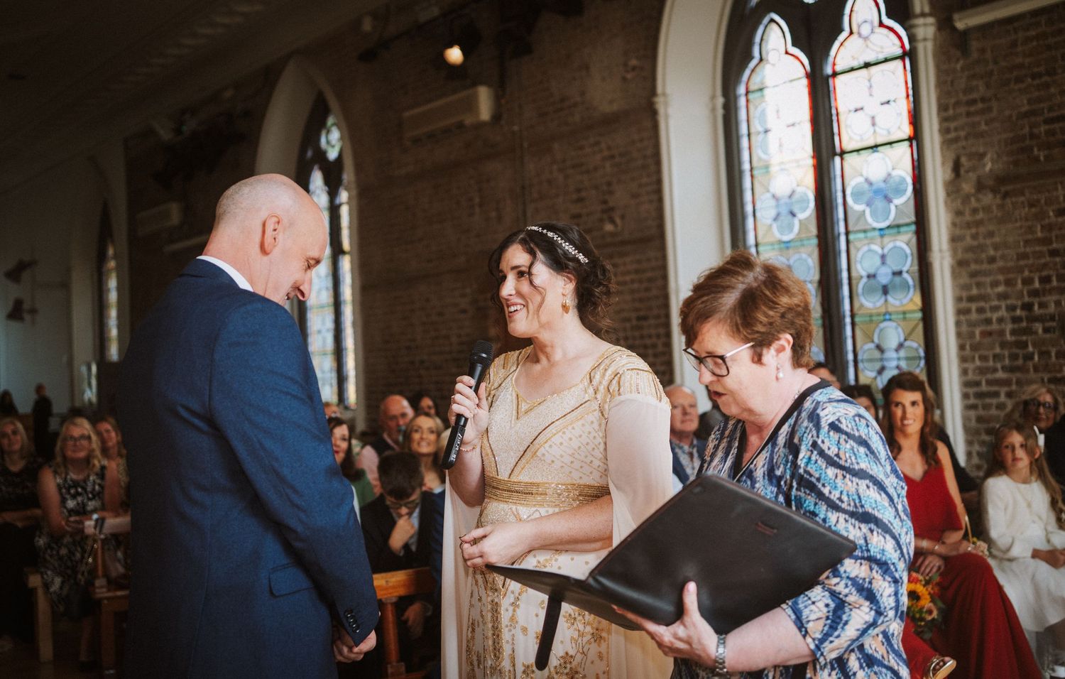 A couple shares a special dance at their wedding reception in a rustic brick-walled venue.
