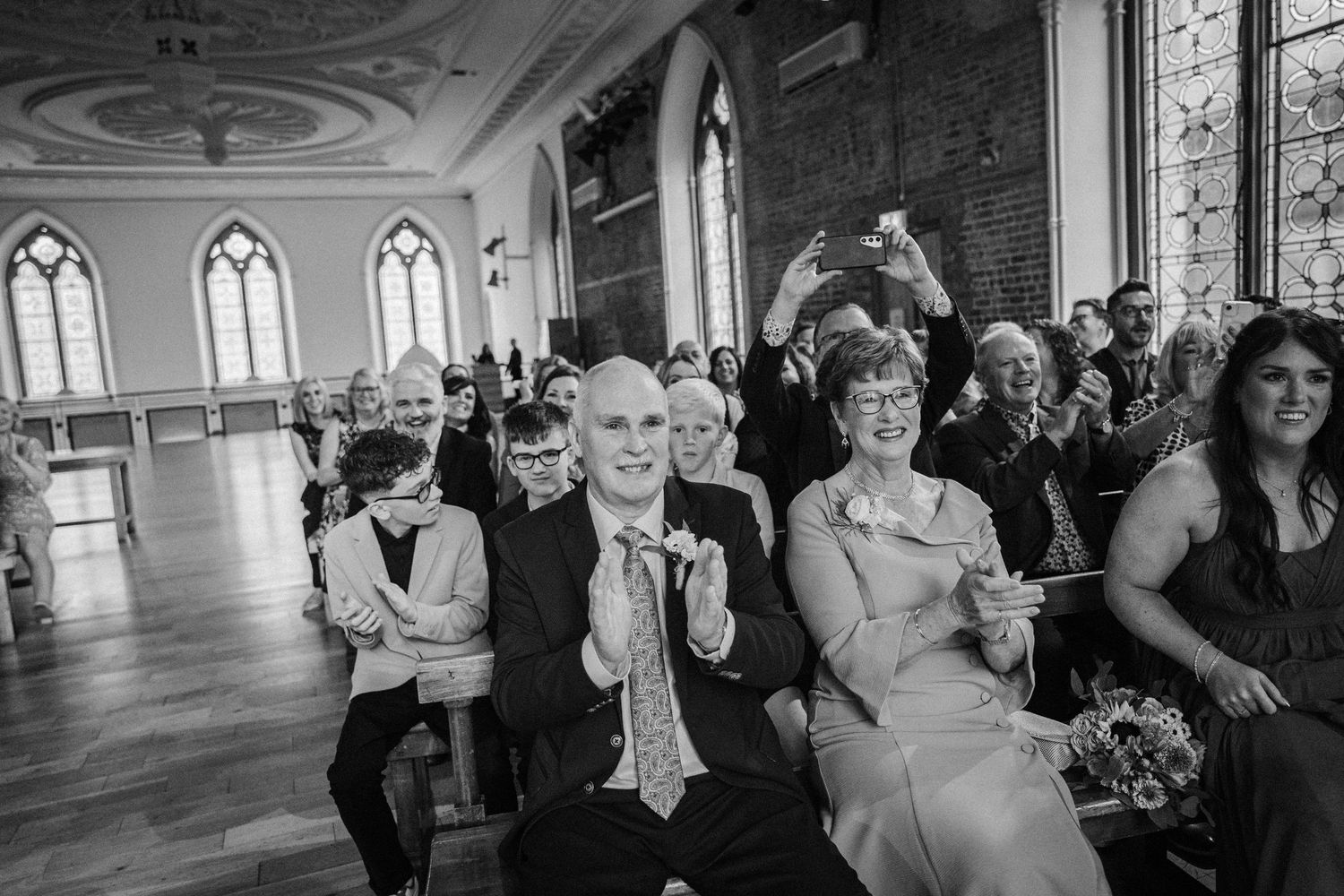 A collection of monochromatic wedding celebration photos showing guests dancing and enjoying festivities.