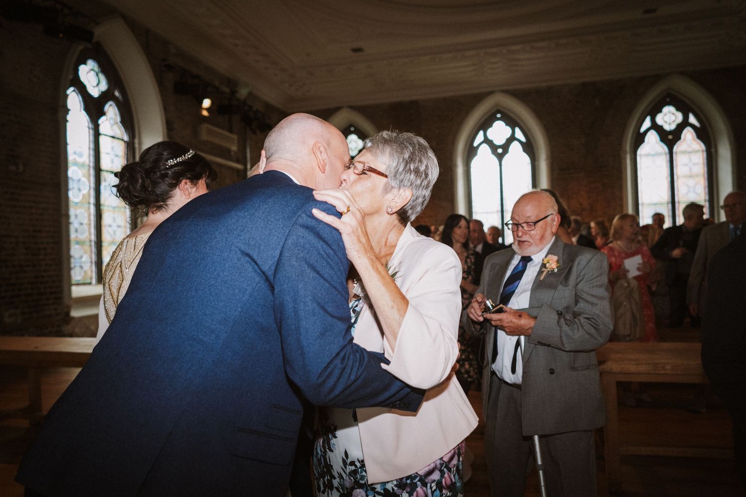 Six candid black and white wedding photos show tender moments of a couple dancing and embracing in a church setting.