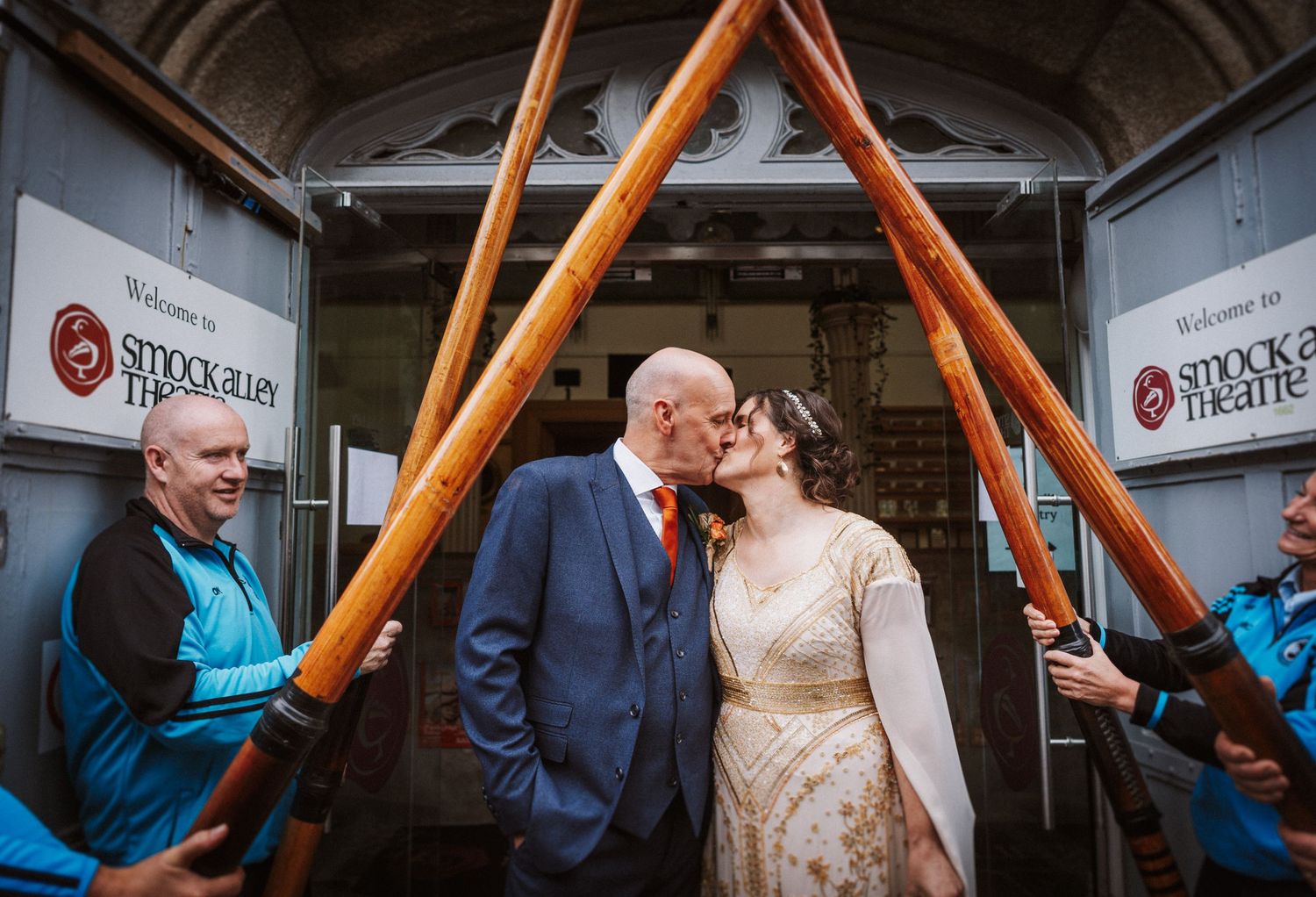 Artistic wedding photo captured in subway car interior with orange handrails creating leading lines.